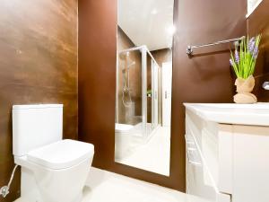 a bathroom with a toilet and a sink and a mirror at Modern 3 Bedroom Apartment Near Belém Lisbon Upto 5 Guests in Cruz Quebrada
