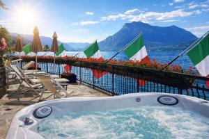 a hot tub on a balcony with a view of the water at Hotel Meridiana in Bellano