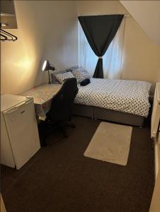a bedroom with a bed and a desk and a window at Lubona Stirchley Guest House in Birmingham +16 photos