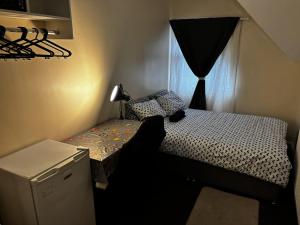 a small bedroom with a bed and a window at Lubona Stirchley Guest House in Birmingham