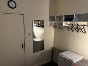a room with a closet with a clock on the wall at Lubona Stirchley Guest House in Birmingham