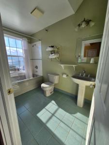a green bathroom with a toilet and a sink at Louisbourg Harbour Inn in Louisbourg +91 photos