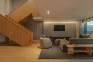a living room with a staircase and a couch at Wake BioHotel, a Member of Design Hotels in Medellín