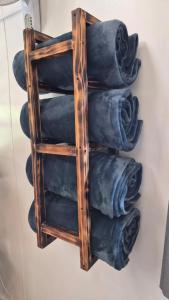 a wooden towel rack with blue towels on a wall at Arch Cabins Self Catering Homes Storms River in Stormsrivier +93 photos