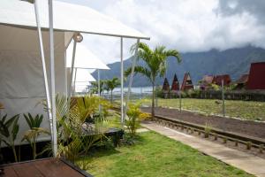 a white tent with a view of the ocean at Ohara Glamping in Kubupenlokan