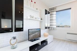 a white living room with a television on a counter at Strandhaferweg 1 Utkiekerblick in Burgtiefe auf Fehmarn 