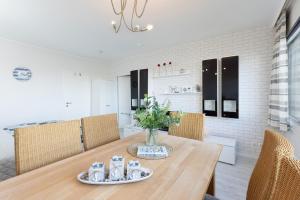 a dining room with a wooden table and chairs at Strandhaferweg 1 Utkiekerblick in Burgtiefe auf Fehmarn 
