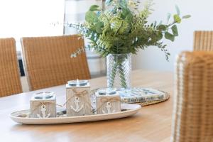 a table with a vase of flowers and a plate with candles at Strandhaferweg 1 Utkiekerblick in Burgtiefe auf Fehmarn 