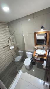 a bathroom with a toilet and a sink and a shower at Hotel Wilson Rio Claro in Río Claro