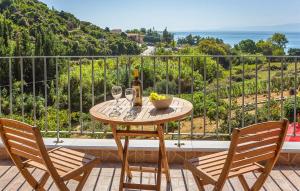 a table with two chairs and wine glasses on a balcony at Villa Giorgio by Villa Select in Kefallonia