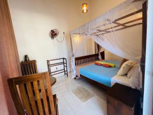 a bedroom with a bed with a mosquito net at Tango Sunrise Villa in Tangalle