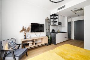 a living room with a tv on a wall at Apartamenty Wolności 6 self check-in in Poznań