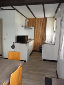 a room with a kitchen with a table and a sink at Schophemmerhoeve in Voeren