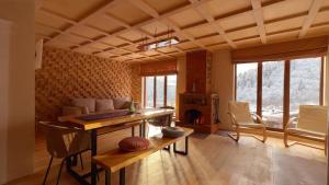 a living room with a table and a fireplace at Eko cottages in Borjomi