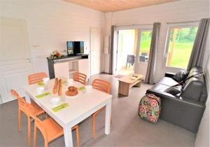 a living room with a white table and a couch at ZEcamping 3 étoiles pet friendly animations piscine chauffée in Merdrignac