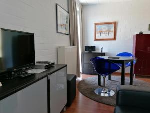 ein Wohnzimmer mit Fernseher und einem blauen Sessel in der Unterkunft Studio's Park - Heverlee in Löwen