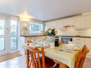 a kitchen with a table with chairs and a vase of flowers at 2 Bed in Holt oc-ncc11 in Holt