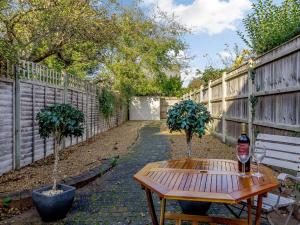 a table with a bottle of wine next to a fence at 2 Bed in Holt oc-ncc11 in Holt