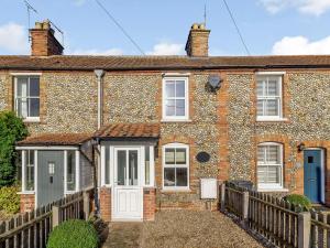 a brick house with a wooden fence in front of it at 2 Bed in Holt oc-ncc11 in Holt +2 photos