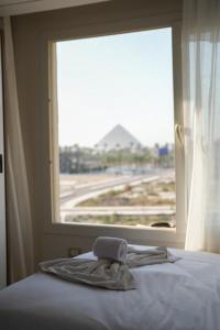 a bed with a window with a towel on it at home in the pyramids in Cairo