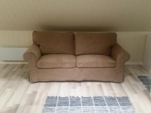 a brown couch sitting in a living room at Ormåsen Loft in Ormåsen