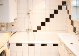 a bathroom with a bath tub and a sink at Seehütte Tamberger in Feld am See +6 photos
