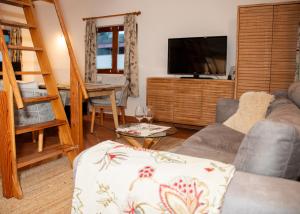 a living room with a couch and a flat screen tv at Seehütte Tamberger in Feld am See