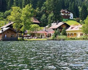a group of houses on the shore of a body of water at Seehütte Tamberger in Feld am See