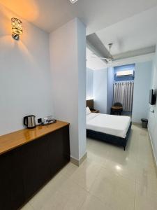 a hotel room with a bed and a desk at Nessa Inn in Sholāshahar
