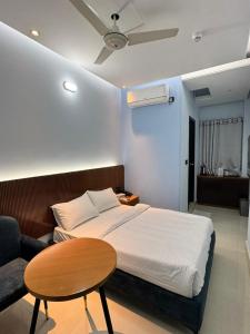 a bedroom with a bed and a table and a couch at Nessa Inn in Sholāshahar