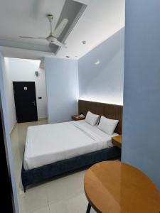 a bedroom with a white bed and a table at Nessa Inn in Sholāshahar