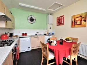 a kitchen with a table with a red table cloth at 5 Bed in Alnwick oc-60497 in Alnwick