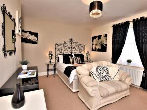 a bedroom with a bed and a couch and a chair at 5 Bed in Alnwick oc-60497 in Alnwick