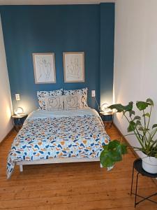 a bedroom with a bed with blue walls and a plant at Renovated charming appartment in Strasbourg