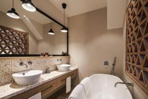 ein Badezimmer mit zwei Waschbecken und einer Badewanne in der Unterkunft Borgo 69 Villas & Suites in Foiano della Chiana + 69 Fotos