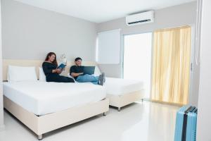 two women sitting on beds in a hospital room at Ribai Hotels -Riohacha in Ríohacha