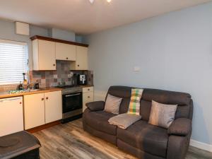 a living room with a brown couch in a kitchen at Long Jack's in Ballygarrett +3 photos