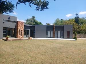 a modern house with a lawn in front of it at Donido's Place in Alberton