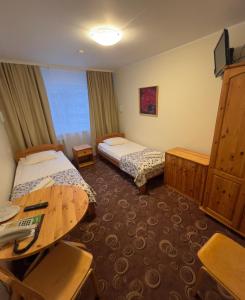 a hotel room with two beds and a desk at Dorell in Tallinn
