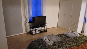 a living room with a bed and a flat screen tv at Stuga Sandhem in Sandhem