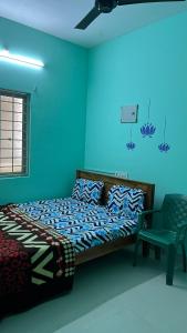 a blue bedroom with a bed and a chair at STAR Residency - G in Pondicherry +13 photos