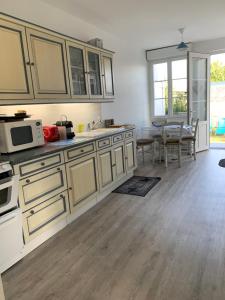 a kitchen with white cabinets and a table with a microwave at VILLA CATHY in Dives-sur-Mer