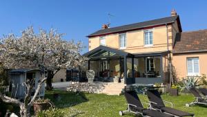a house with two chairs in the yard at VILLA CATHY in Dives-sur-Mer