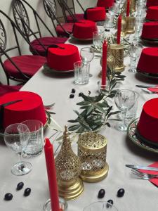 a long table with red and gold plates and red candles at Villa Atika in El Bougaria +53 photos