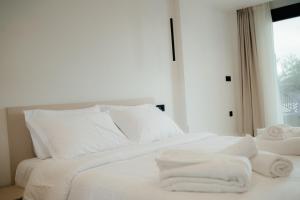 a white bed with white sheets and towels on it at Malou and Charma Villas in Syvota +50 photos