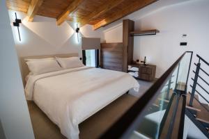 a bedroom with a white bed and a staircase at Malou and Charma Villas in Syvota