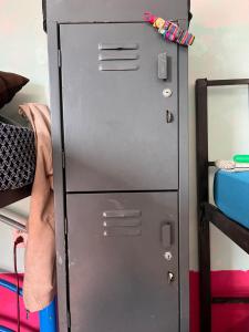 ein Metallschrank in einem Zimmer neben einem Etagenbett in der Unterkunft Rancho House in Cancún