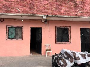 ein rosa Haus mit einem Stuhl davor in der Unterkunft Rancho House in Cancún