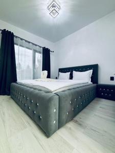 a bedroom with a large bed with a black headboard at Casuta cu ciubar Valea Avrigului - Secret Forest in Avrig +25 photos