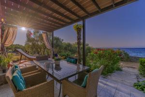 a patio with a table and chairs and the ocean at Villa Biankura in Blato